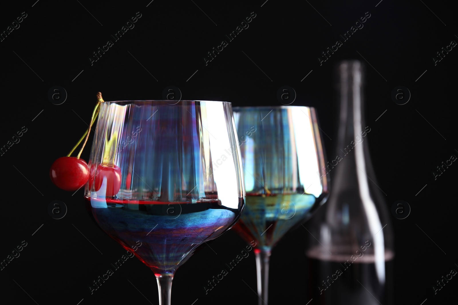 Photo of Delicious cherry wine with ripe juicy berries on black background, closeup