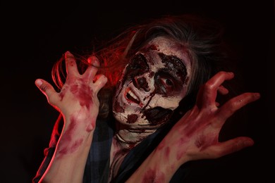 Photo of Scary zombie on dark background. Halloween monster