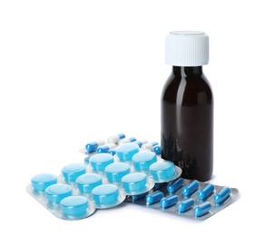 Photo of Bottle of cough syrup and different pills on white background