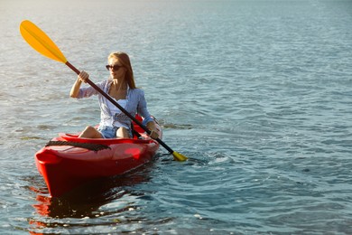 Beautiful woman kayaking on river, space for text. Summer activity