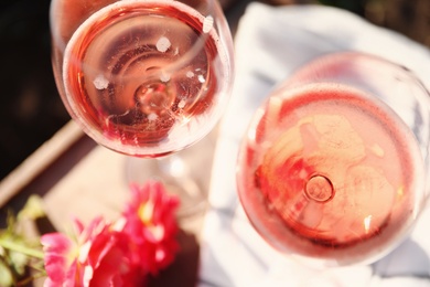 Photo of Glasses of rose wine on table, above view