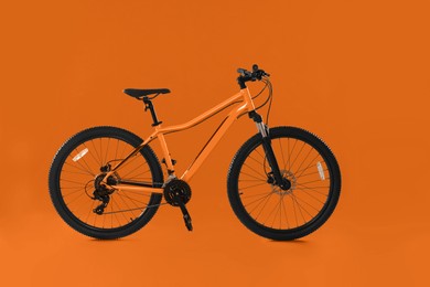 Image of Modern bicycle on orange background. Healthy lifestyle