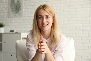 Woman talking to her coworkers through video conference indoors, view from webcam