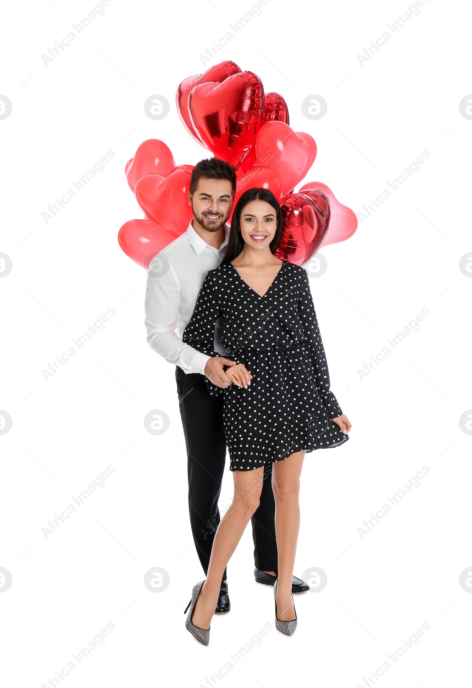 Photo of Happy young couple with heart shaped balloons isolated on white. Valentine's day celebration