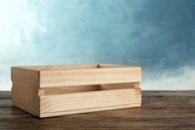 Photo of Wooden crate on table against color background. Space for text