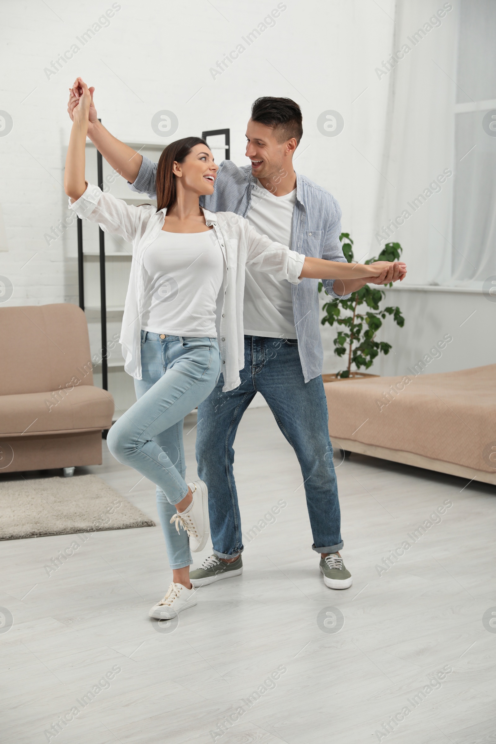 Photo of Happy young couple dancing together at home