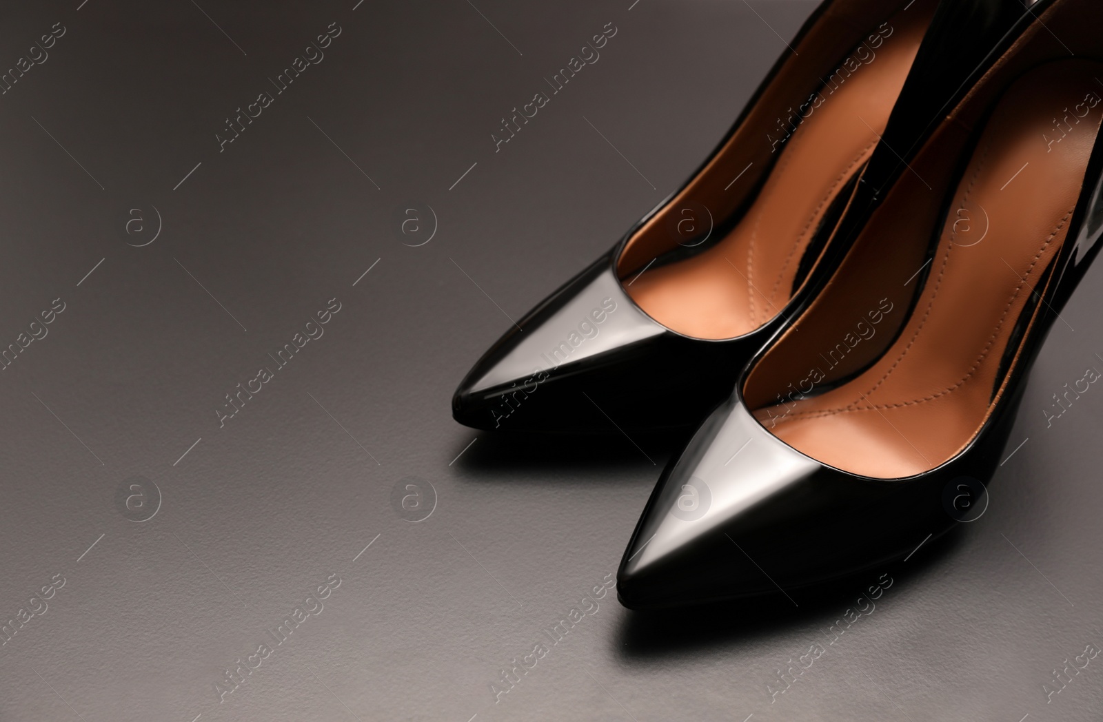 Photo of Beautiful high heel shoes on grey background. Space for text