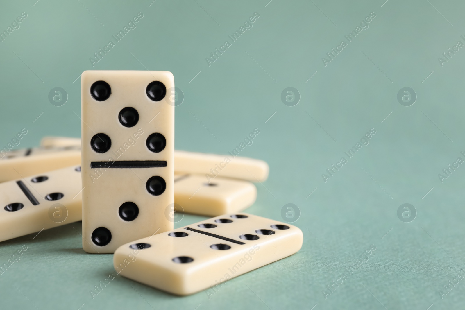 Photo of Classic domino tiles on grey background, closeup. Space for text