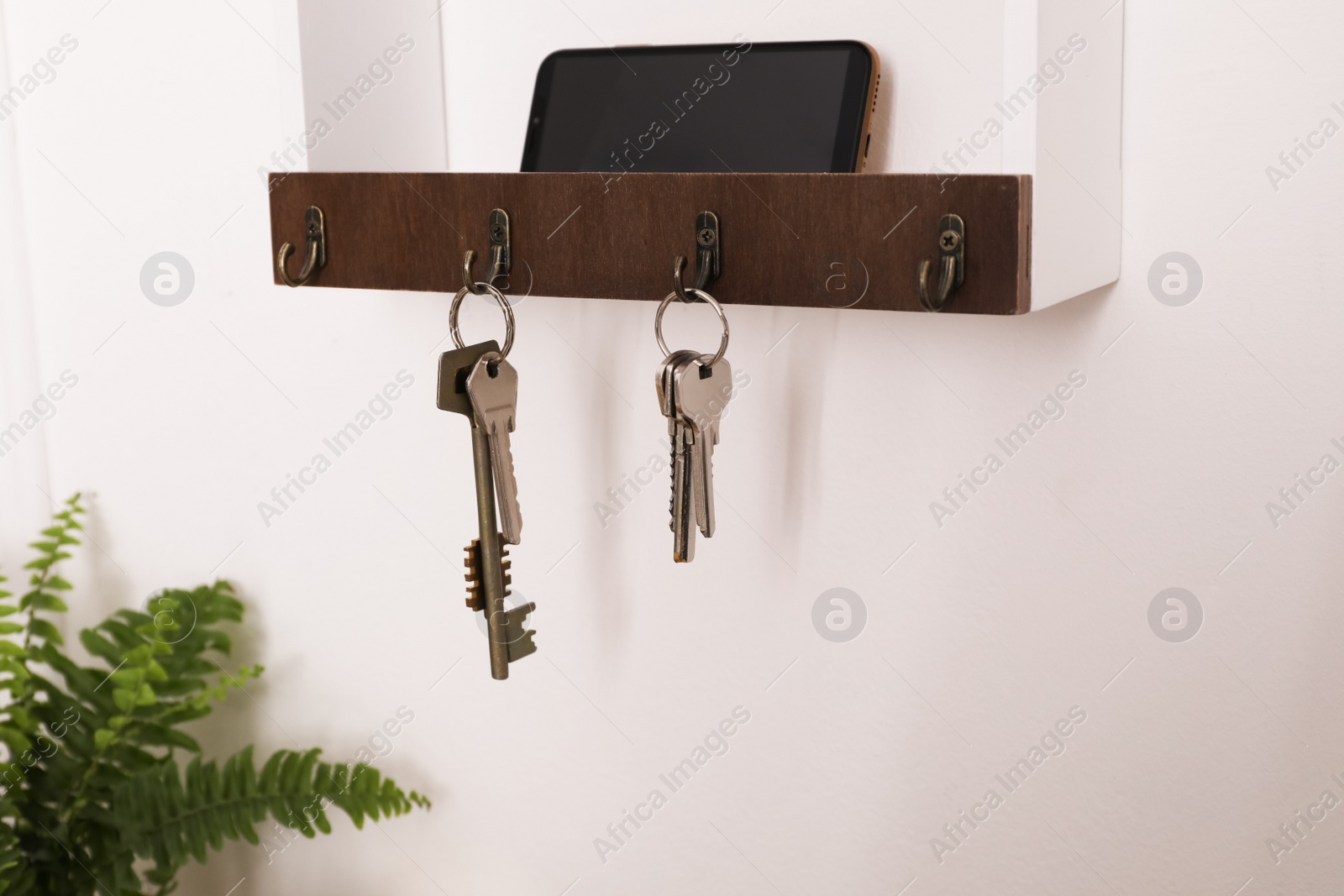 Photo of Wooden hanger for keys on white wall