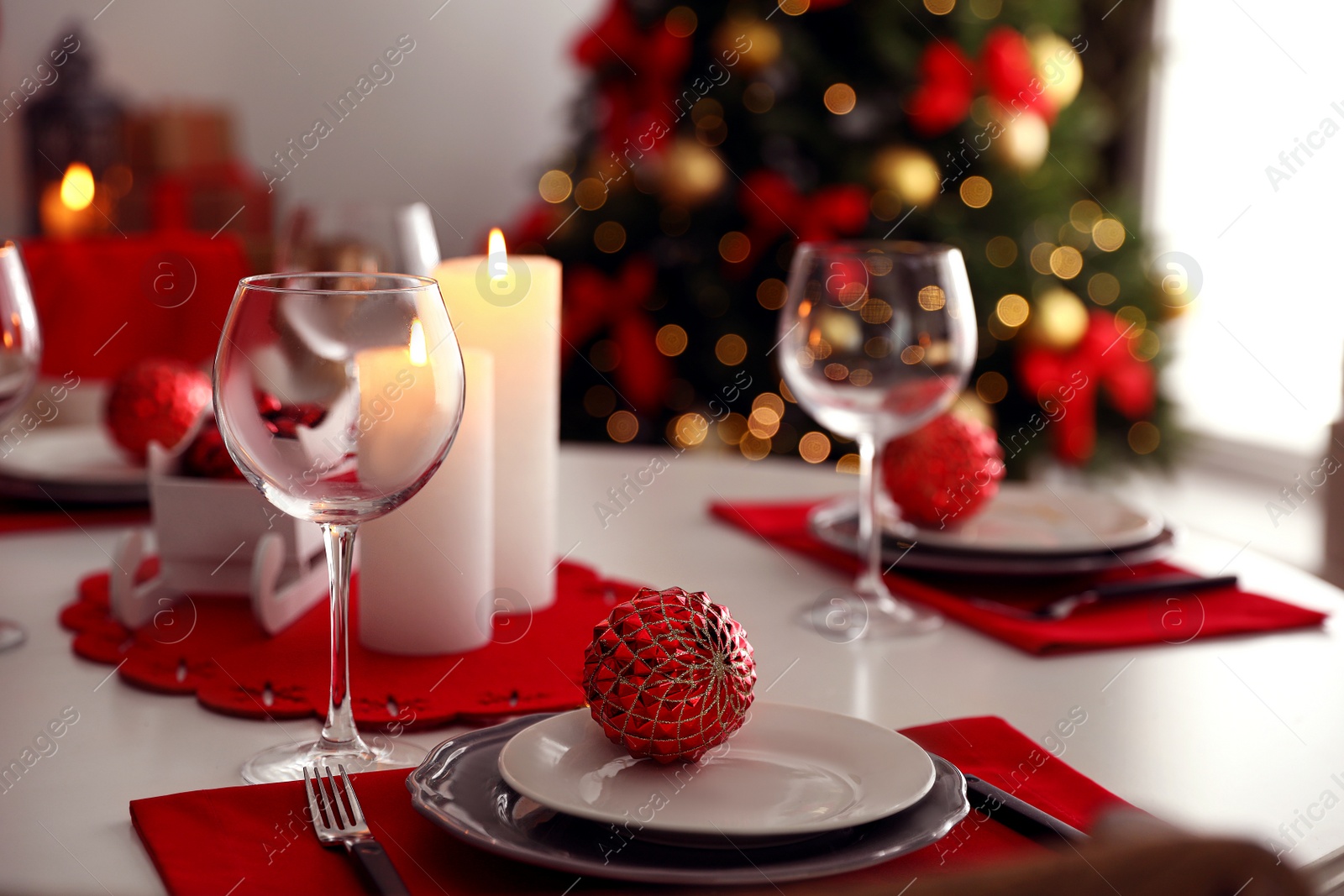 Photo of Festive table setting and Christmas tree in stylish room interior