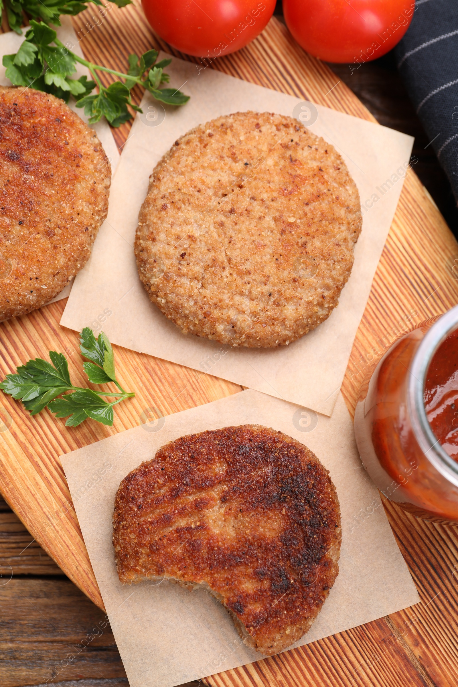 Photo of Delicious vegan cutlets and sauce on wooden table, top view