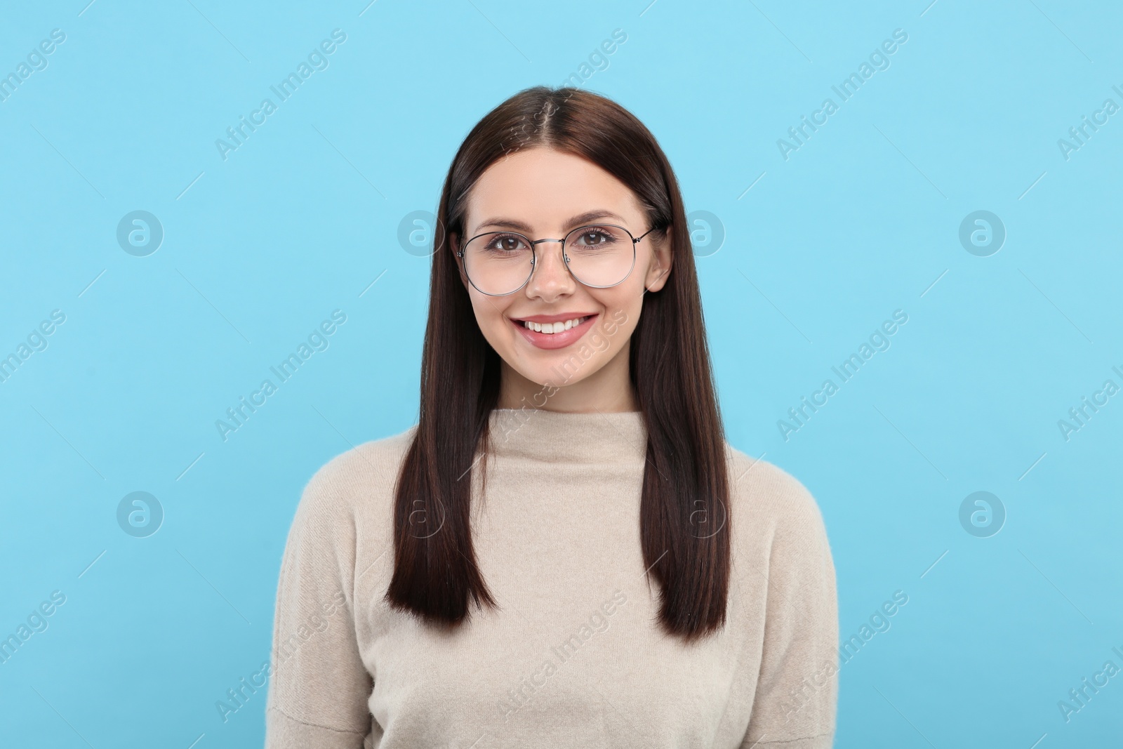 Photo of Portrait of woman in stylish eyeglasses on light blue background