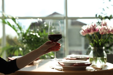 Photo of Woman with glass of wine in restaurant, closeup