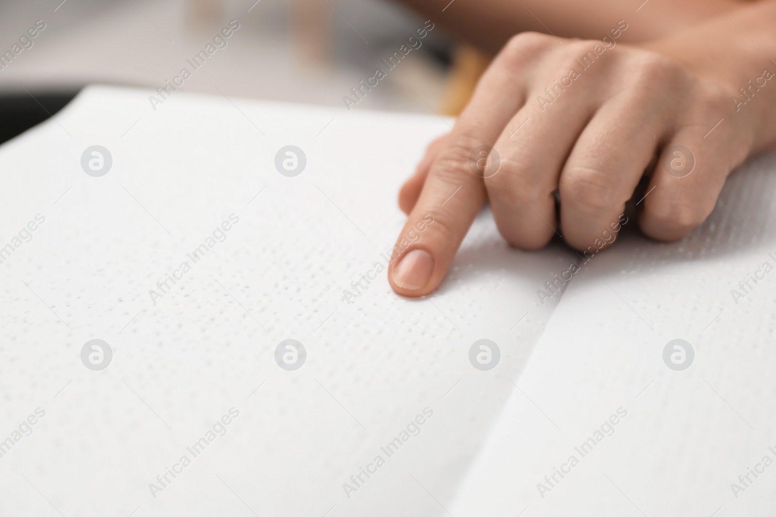 Photo of Blind woman reading book written in Braille, closeup