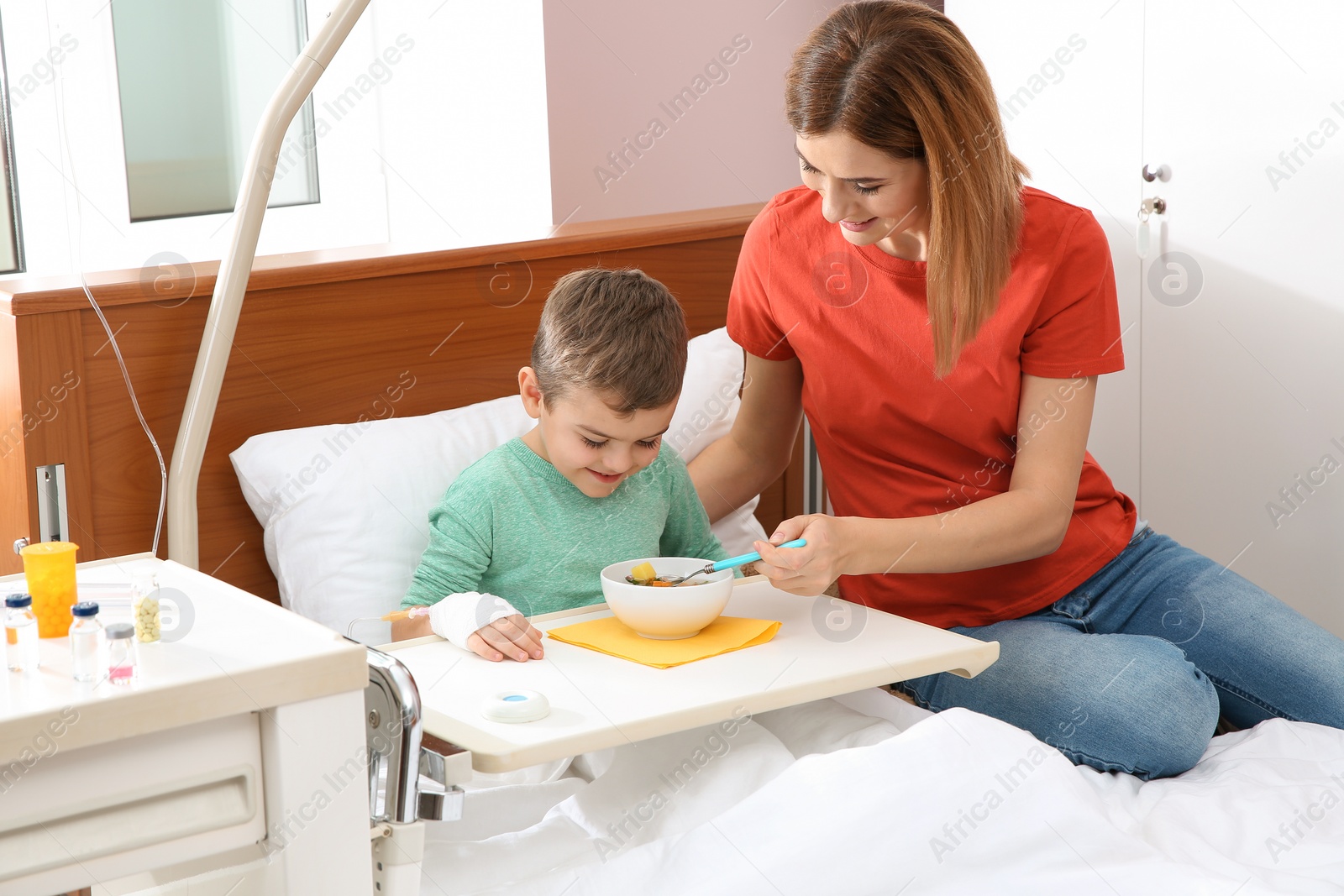 Photo of Woman feeding her little child with soup in hospital