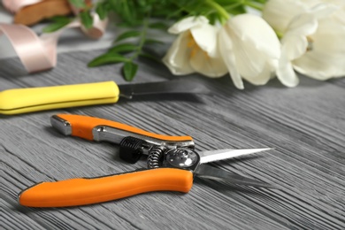 Florist workplace with pruning snips and knife on table