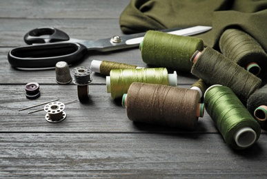 Bobbins with threads on table. Tailoring accessories