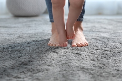 Photo of Baby doing first steps with mother's help, closeup