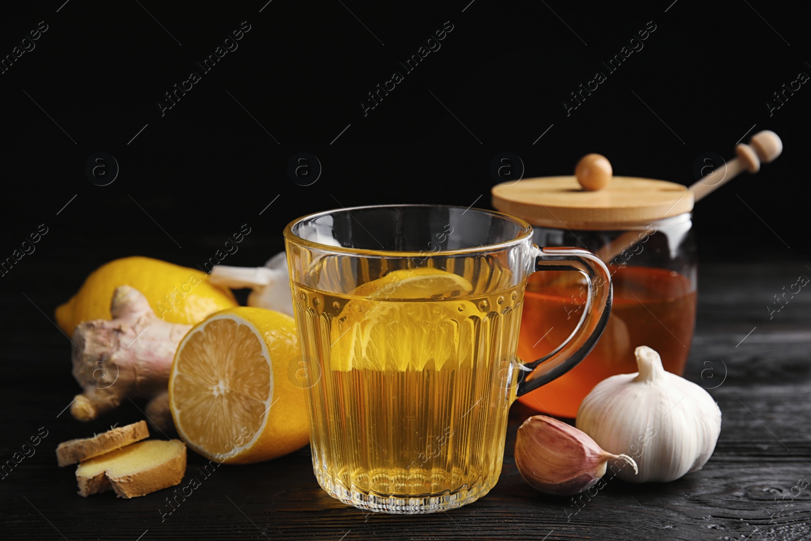 Photo of Composition with cold remedies on black wooden table. Sore throat treatment