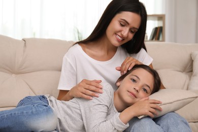 Photo of Happy mother and daughter on sofa at home. Single parenting