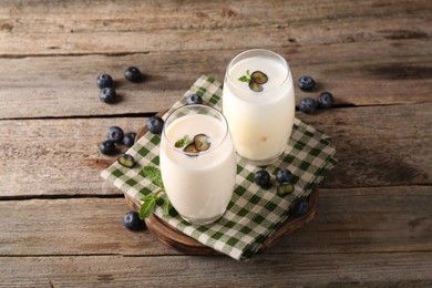 Photo of Composition with tasty yogurt in glasses and blueberries on wooden table