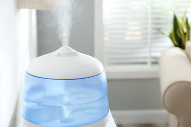 Photo of Modern air humidifier at home, closeup view. Space for text