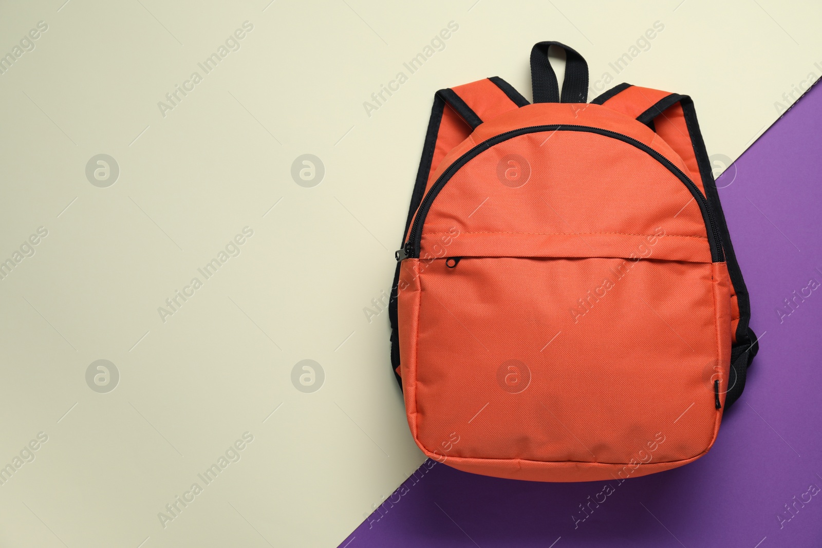 Photo of Stylish orange backpack on color background, top view. Space for text