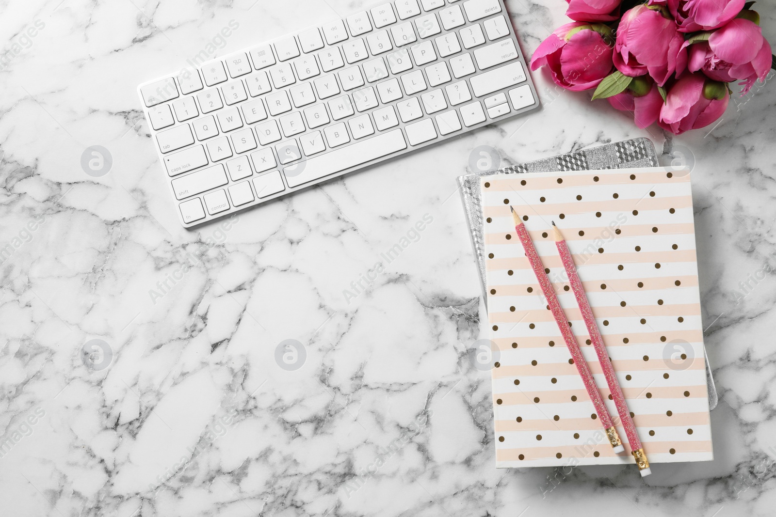 Photo of Stylish workplace with fragrant peonies on marble table, flat lay. Space for text