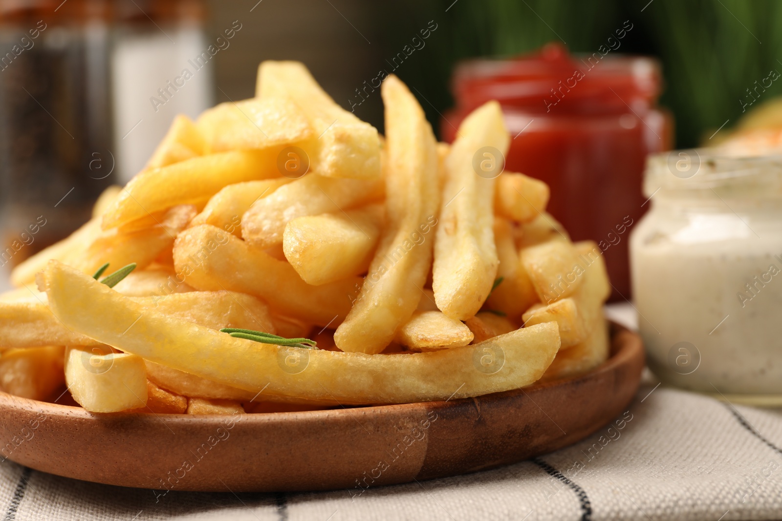 Photo of Delicious french fries served with sauces on table, closeup