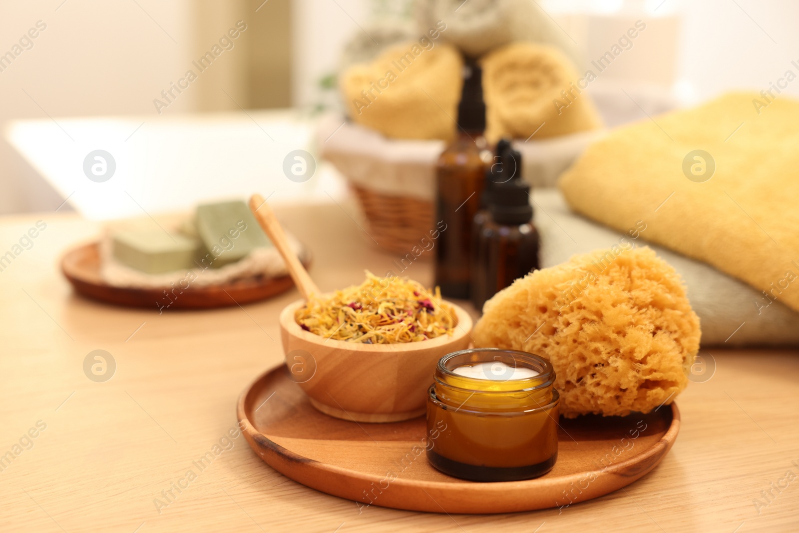 Photo of Dry flowers, loofah and jar with cream on wooden table indoors, space for text. Spa time