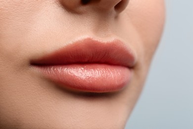 Closeup view of woman with beautiful lips on light background
