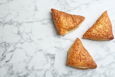 Flat lay composition with fresh delicious puff pastry on white marble table. Space for text