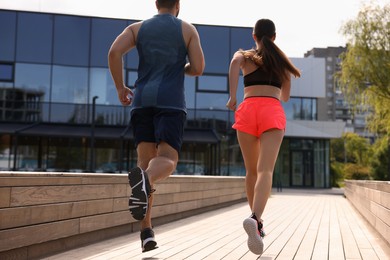 Photo of Healthy lifestyle. Couple running outdoors on sunny day, low angle view