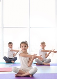 Photo of Little children practicing yoga in gym