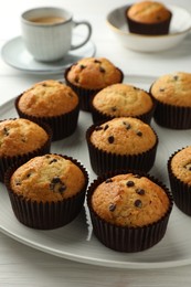 Photo of Delicious freshly baked muffins with chocolate chips on table, closeup