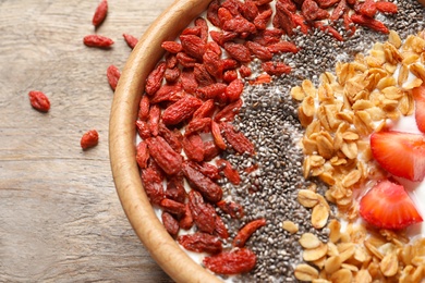 Smoothie bowl with goji berries on wooden table, closeup