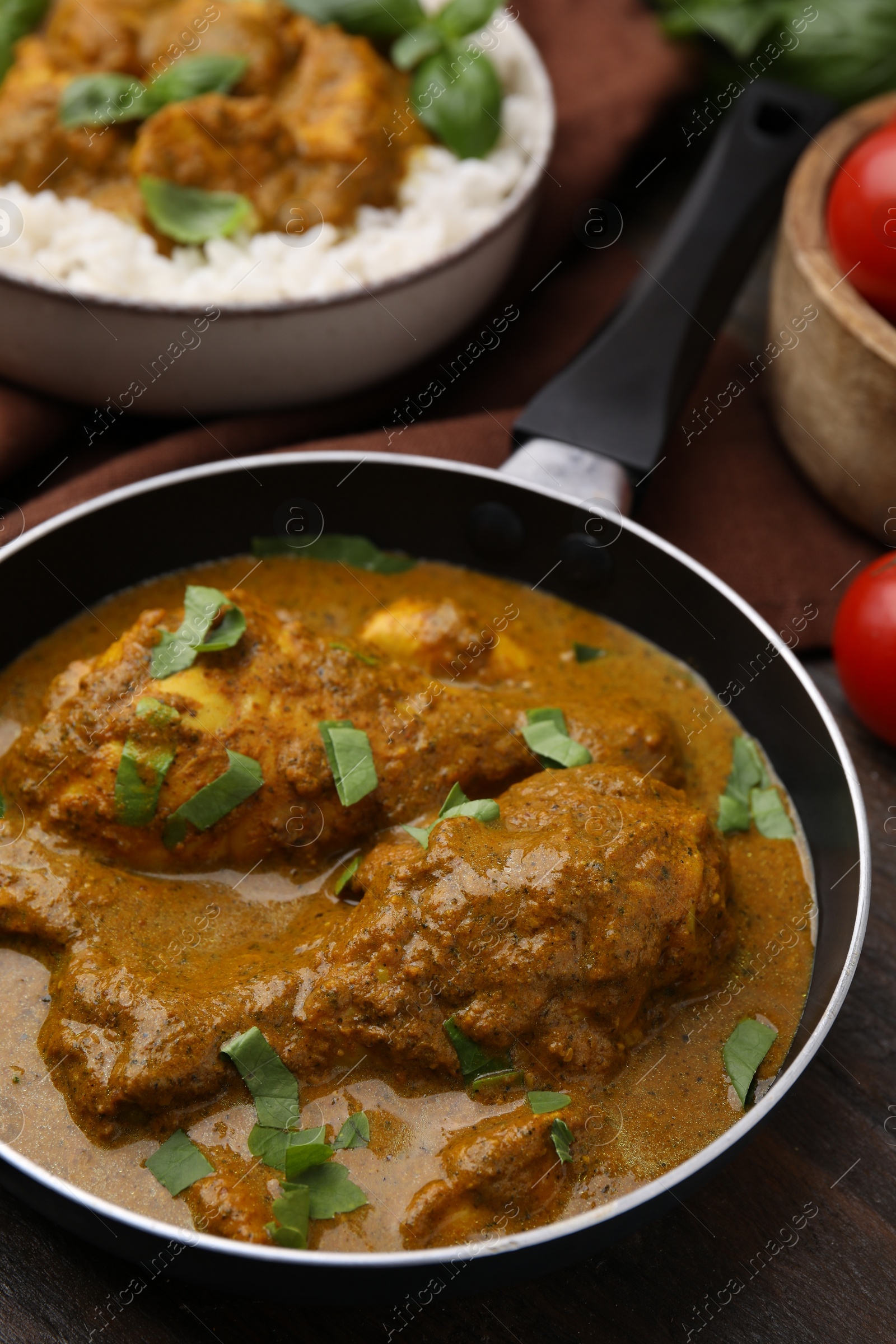 Photo of Delicious chicken with curry sauce served on wooden table, closeup