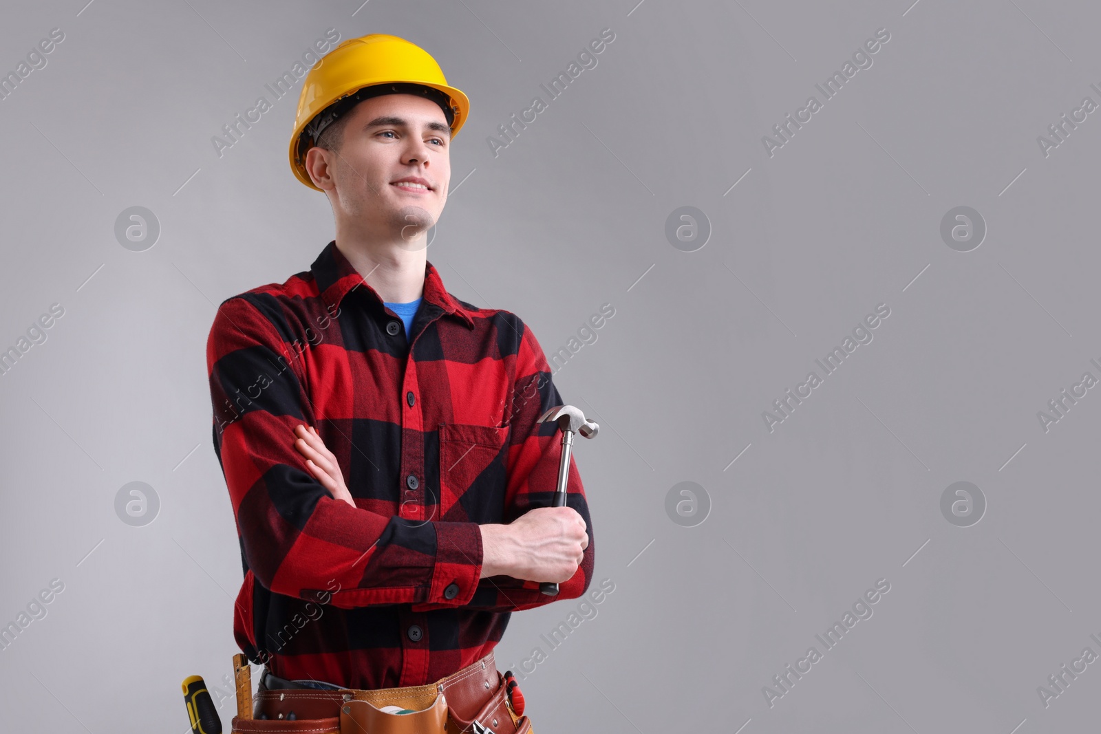 Photo of Professional repairman holding hammer on light grey background. Space for text