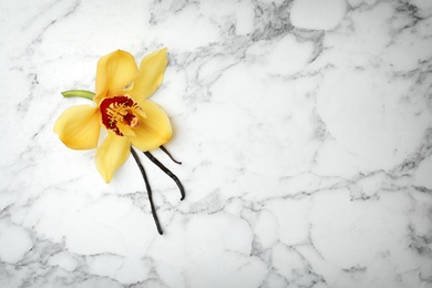 Photo of Beautiful vanilla flower and sticks on marble background