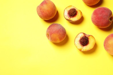 Photo of Delicious juicy peaches on yellow background, flat lay. Space for text
