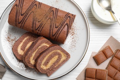 Photo of Tasty chocolate cake roll with cream on white wooden table, flat lay