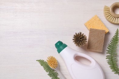 Flat lay composition with different cleaning supplies on light wooden background, space for text