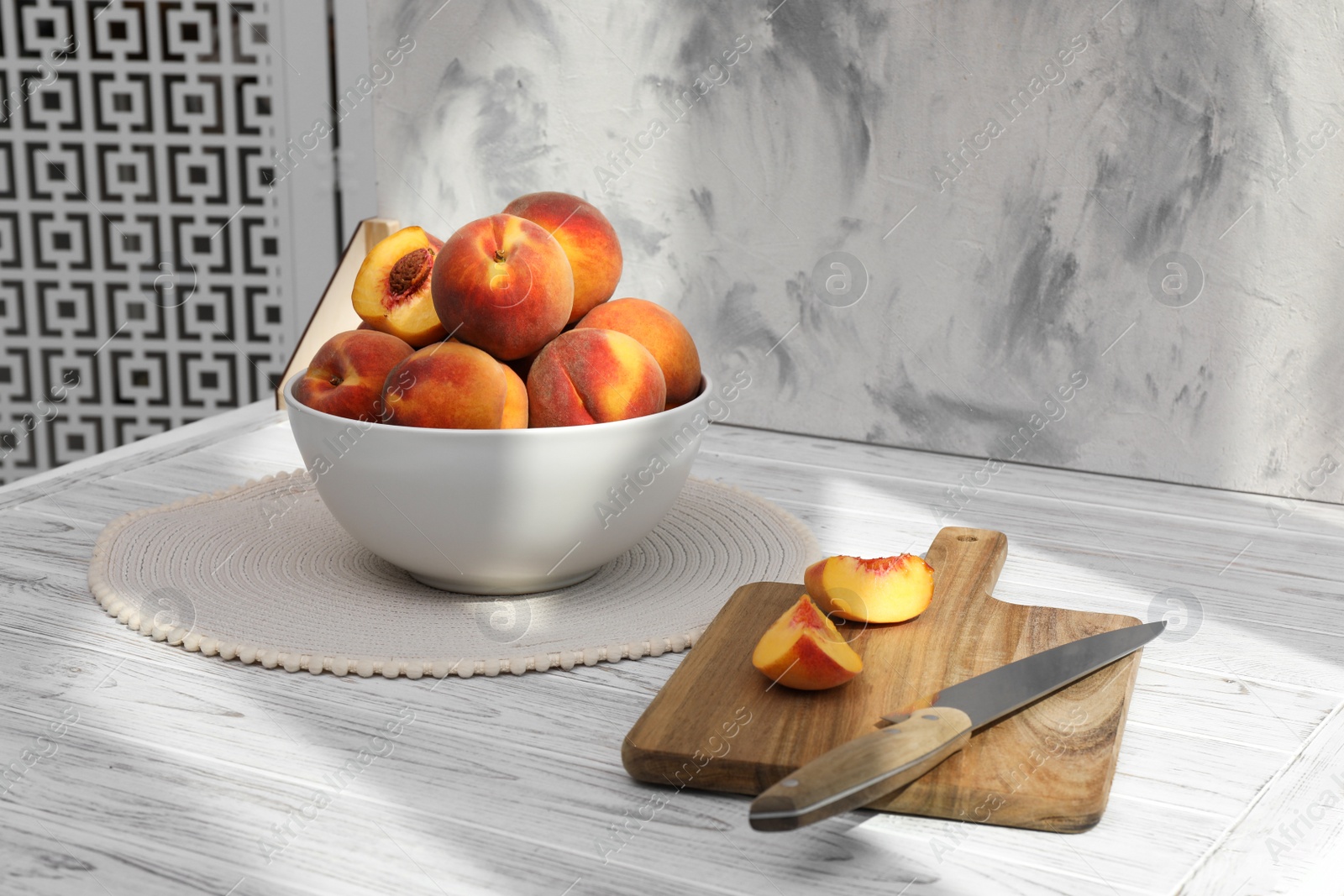 Photo of Bowl of juicy peaches and double-sided backdrop in photo studio