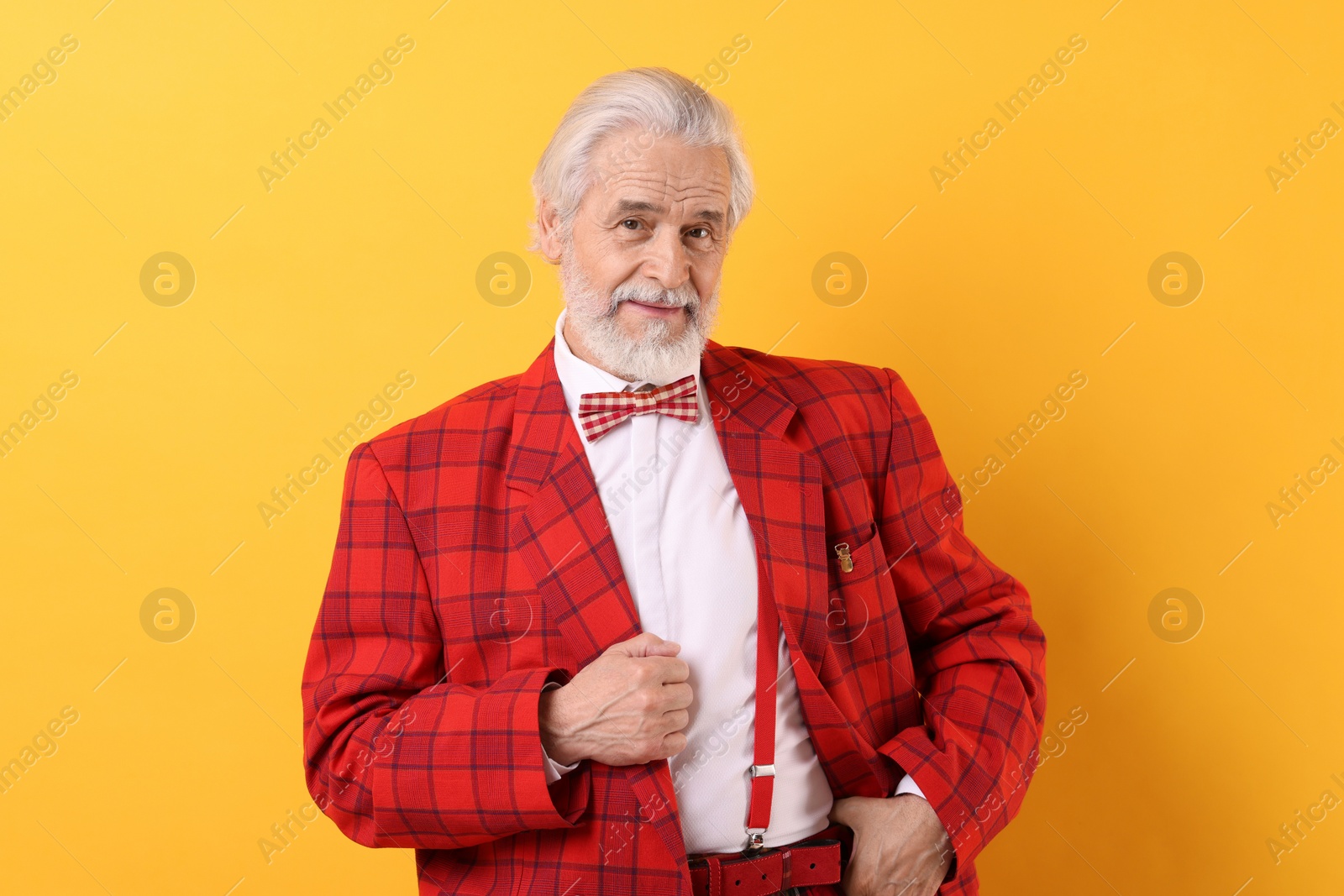 Photo of Portrait of grandpa with stylish red suit and bowtie on yellow background