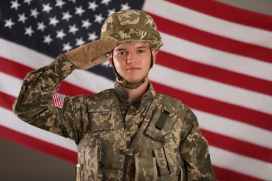 Photo of Male soldier saluting against American flag. Military service