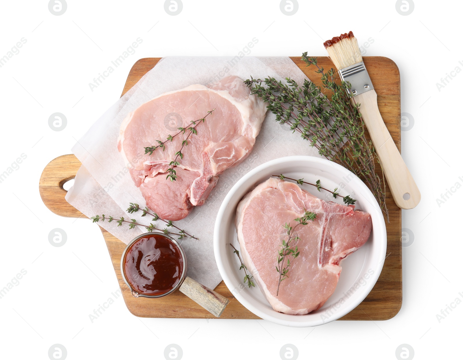 Photo of Board with raw meat, thyme, basting brush and marinade isolated on white, top view