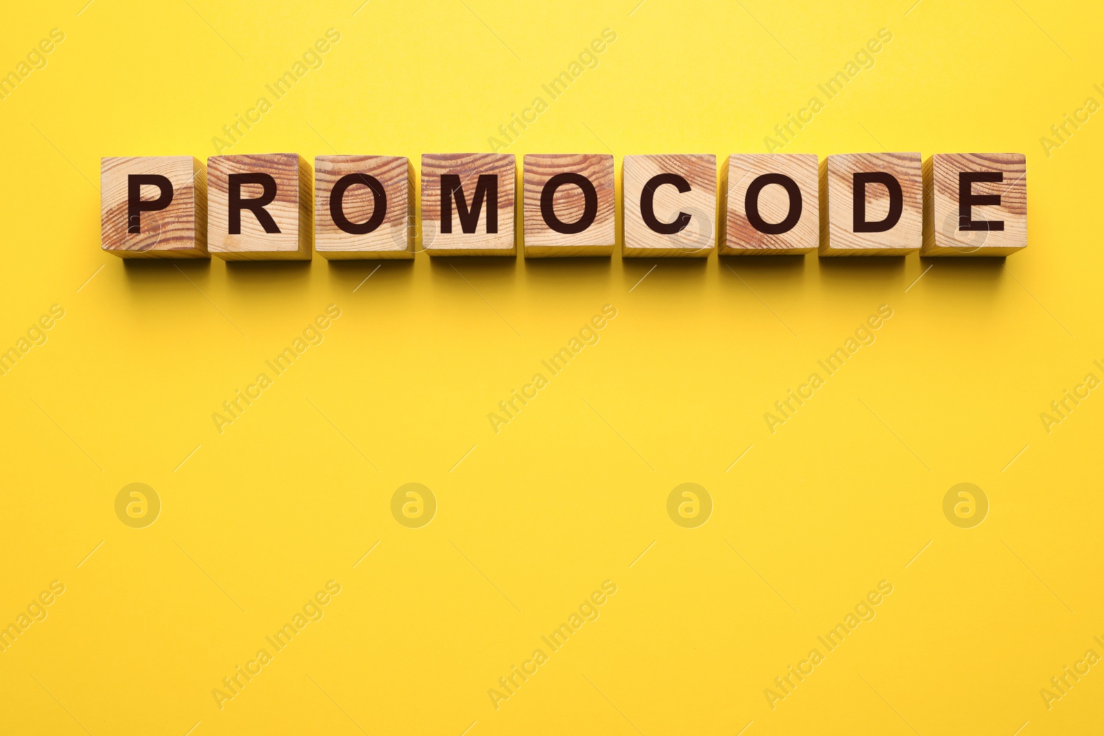 Photo of Word Promocode made of wooden cubes with letters on yellow background, top view. Space for text