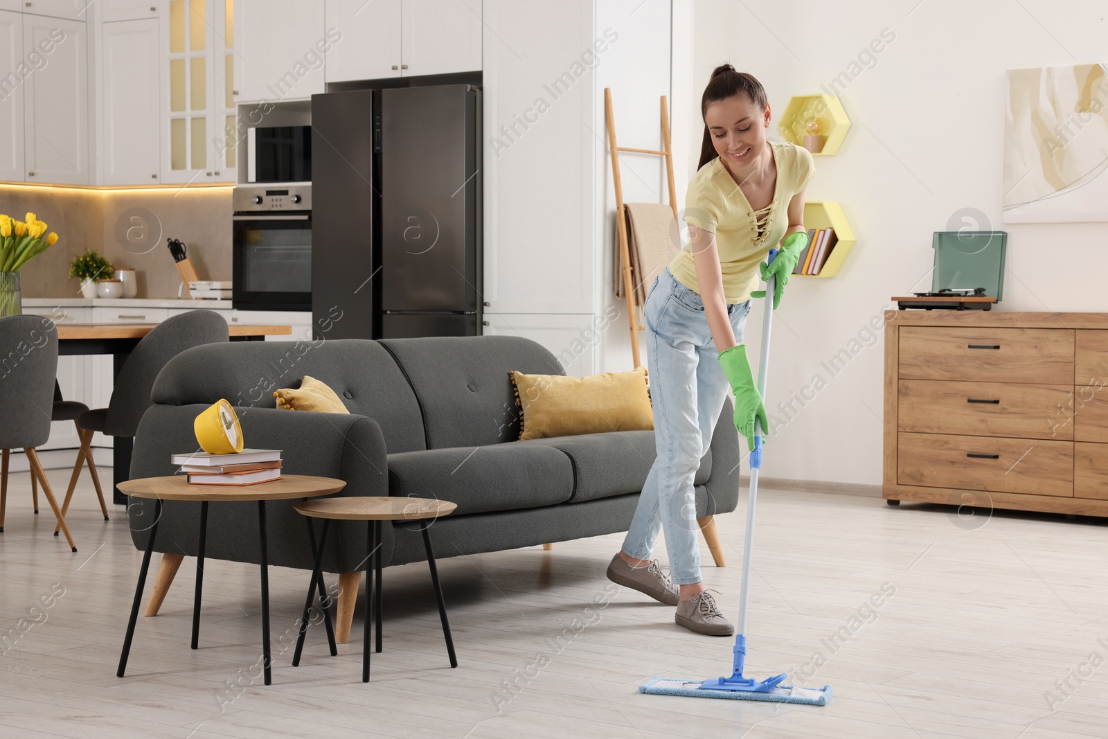 Photo of Spring cleaning. Young woman with mop washing floor at home