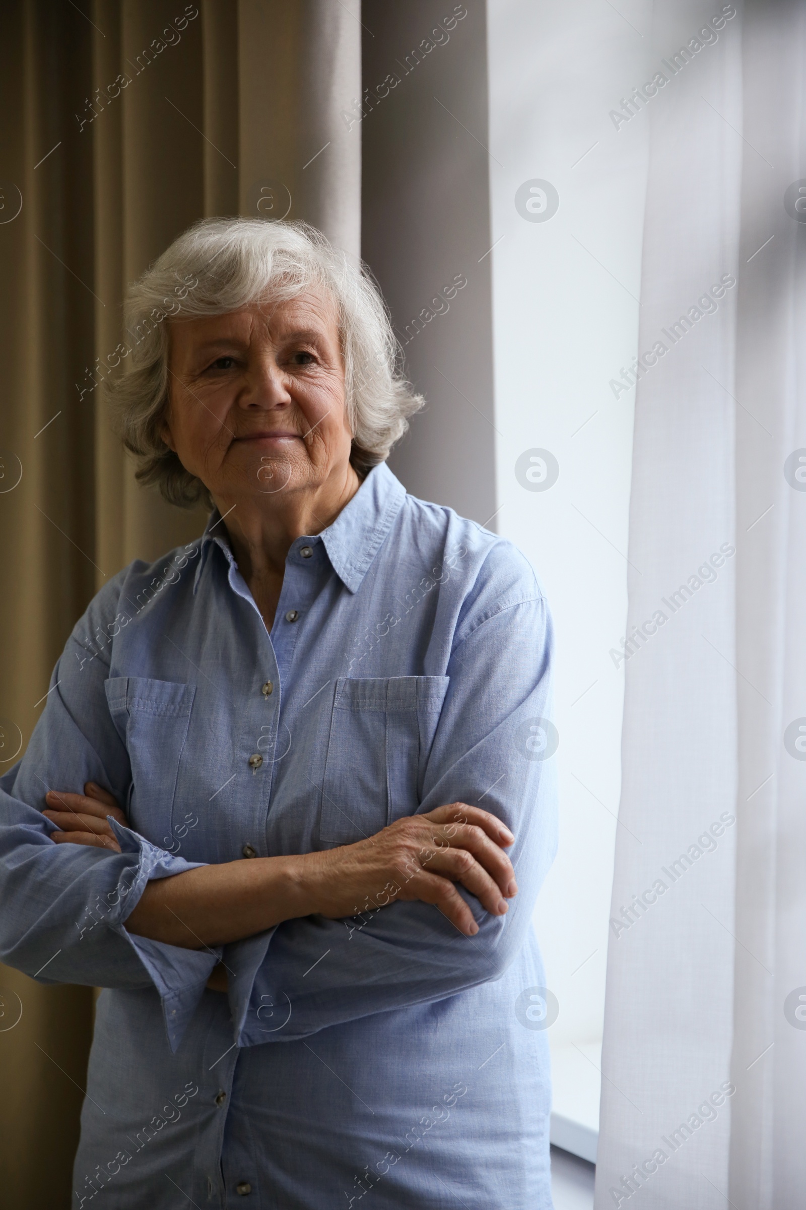 Photo of Portrait of elderly woman near window indoors