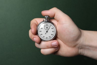 Photo of Man holding vintage timer on green background, closeup